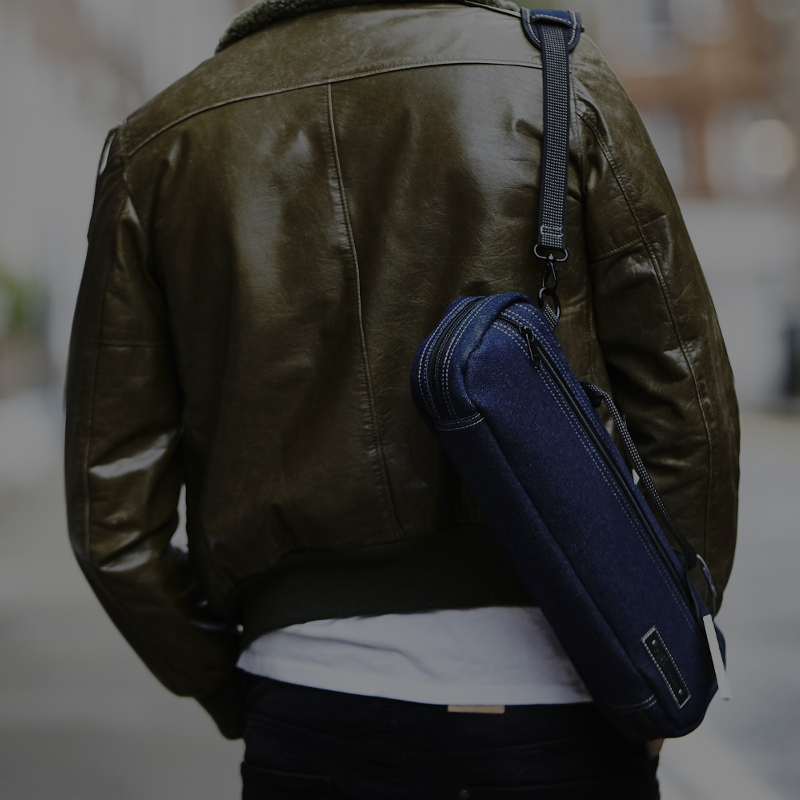 man walking with denim flute bag on his back